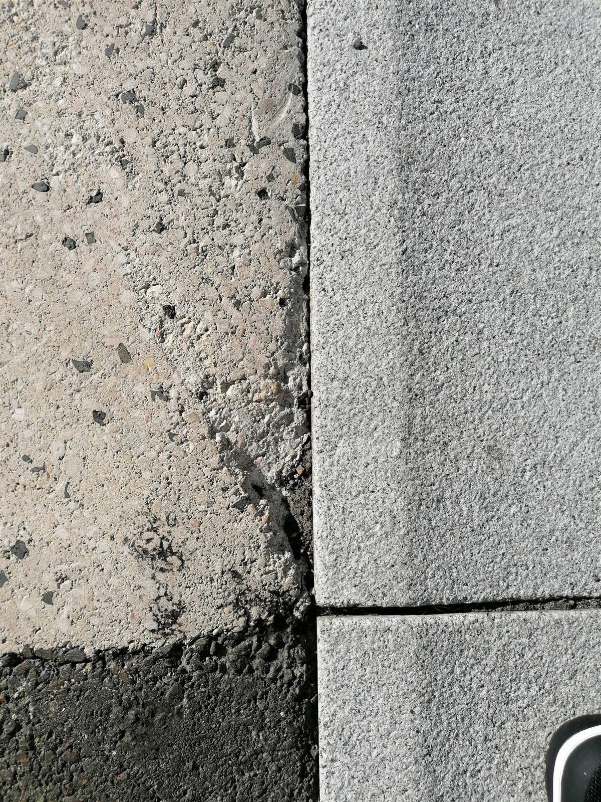 Schadstelle am Entwässerungseinlauf – Vorher: Ausgemagerte, verfärbte Stelle neben dem Einlauf.